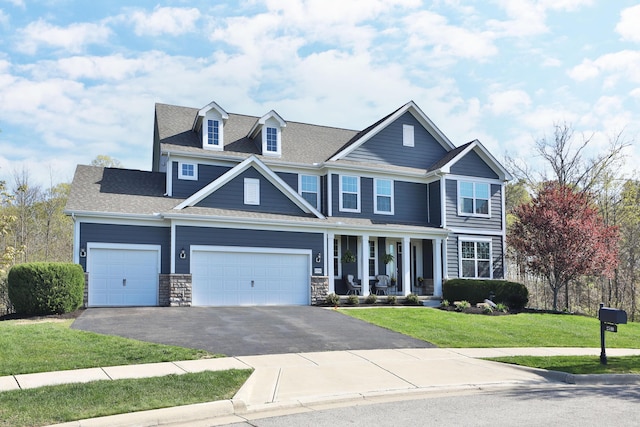 craftsman-style home featuring a porch, a front lawn, driveway, roof with shingles, and an attached garage