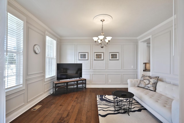 living room with a chandelier, crown molding, visible vents, a decorative wall, and dark wood finished floors