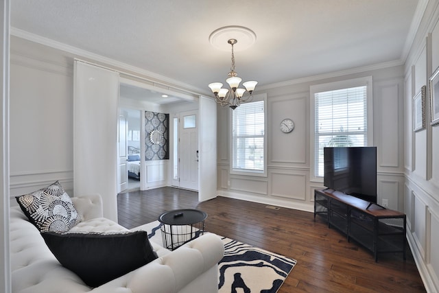 living area with crown molding, dark wood-style floors, an inviting chandelier, and a decorative wall