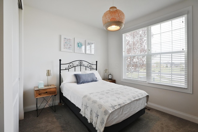bedroom with dark carpet, a closet, and baseboards