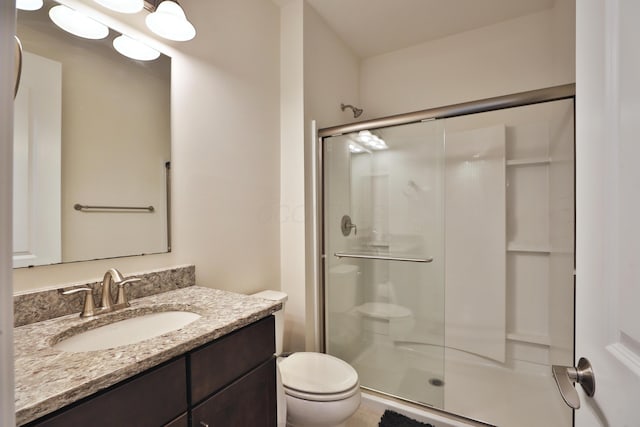 full bathroom featuring toilet, a shower stall, and vanity