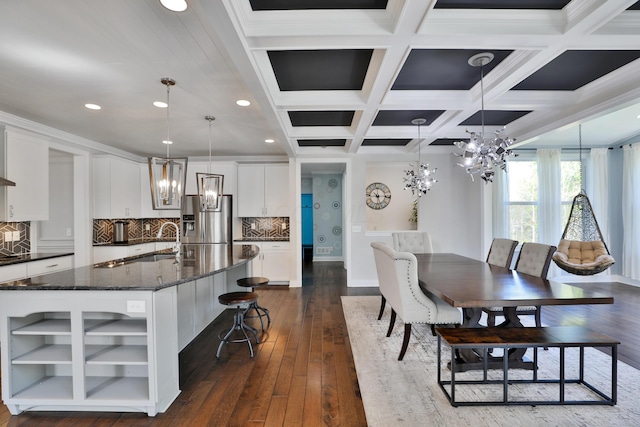 dining area with dark wood finished floors, recessed lighting, an inviting chandelier, coffered ceiling, and beamed ceiling