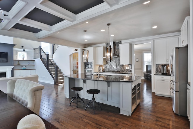 kitchen featuring recessed lighting, stainless steel appliances, beamed ceiling, backsplash, and open floor plan