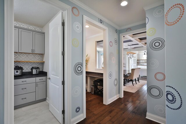 corridor featuring beamed ceiling, recessed lighting, wood-type flooring, crown molding, and coffered ceiling