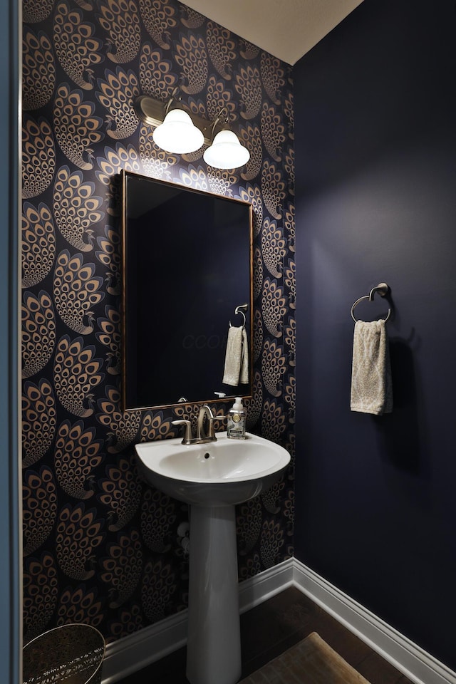 bathroom with wallpapered walls and baseboards