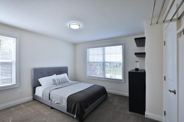 bedroom featuring dark carpet and baseboards
