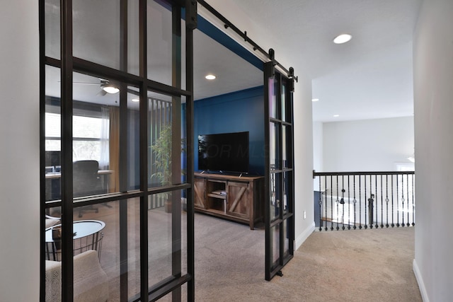 hall featuring a barn door, baseboards, recessed lighting, and carpet floors