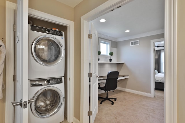 clothes washing area with stacked washer / dryer, crown molding, visible vents, carpet, and laundry area