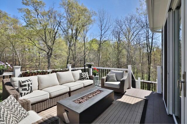 deck featuring an outdoor living space with a fire pit