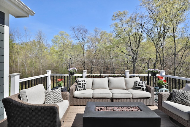 wooden terrace featuring an outdoor living space with a fire pit