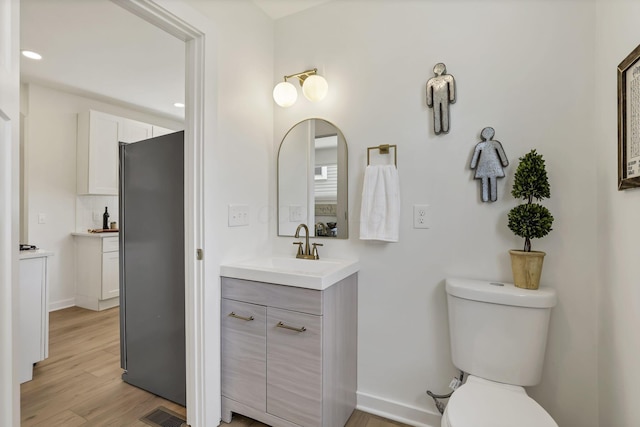 1719 Oak St, Columbus, OH 43205 - bathroom with wood finished floors, vanity, baseboards, toilet, and visible vents