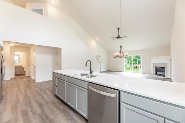325 Woods Edge Loop, Pataskala, OH 43062 - kitchen with appliances with stainless steel finishes, a sink, lofted ceiling, gray cabinets, and a glass covered fireplace