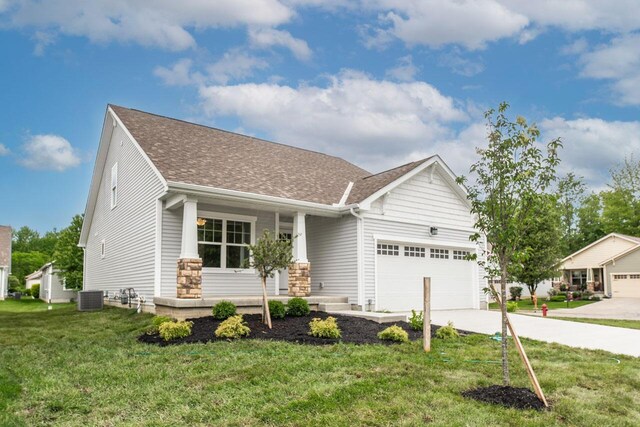 325 Woods Edge Loop, Pataskala, OH 43062 - craftsman-style house featuring central AC unit, a garage, driveway, a front yard, and roof with shingles