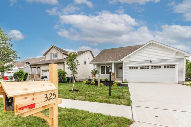 325 Woods Edge Loop, Pataskala, OH 43062 - view of front of property featuring an attached garage, a front lawn, concrete driveway, and a shingled roof