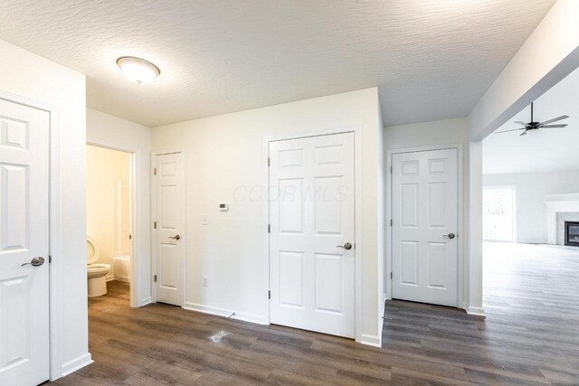 325 Woods Edge Loop, Pataskala, OH 43062 - unfurnished bedroom with dark wood finished floors, baseboards, a fireplace, connected bathroom, and a textured ceiling
