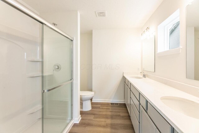 325 Woods Edge Loop, Pataskala, OH 43062 - full bathroom with wood finished floors, toilet, double vanity, and an enclosed shower