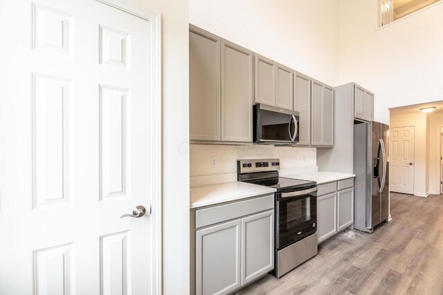 325 Woods Edge Loop, Pataskala, OH 43062 - kitchen with appliances with stainless steel finishes, gray cabinetry, light countertops, and light wood-style flooring