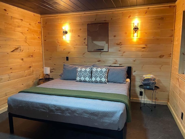 bedroom featuring wood walls, wood ceiling, and concrete flooring