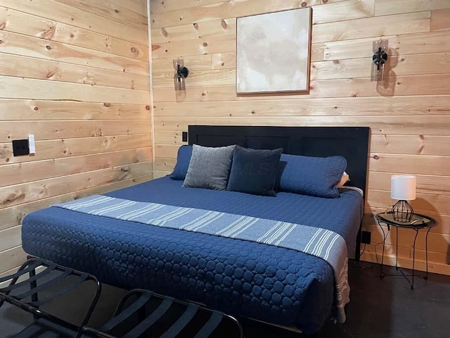 bedroom featuring wooden walls