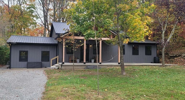 view of front of property with metal roof and a front lawn
