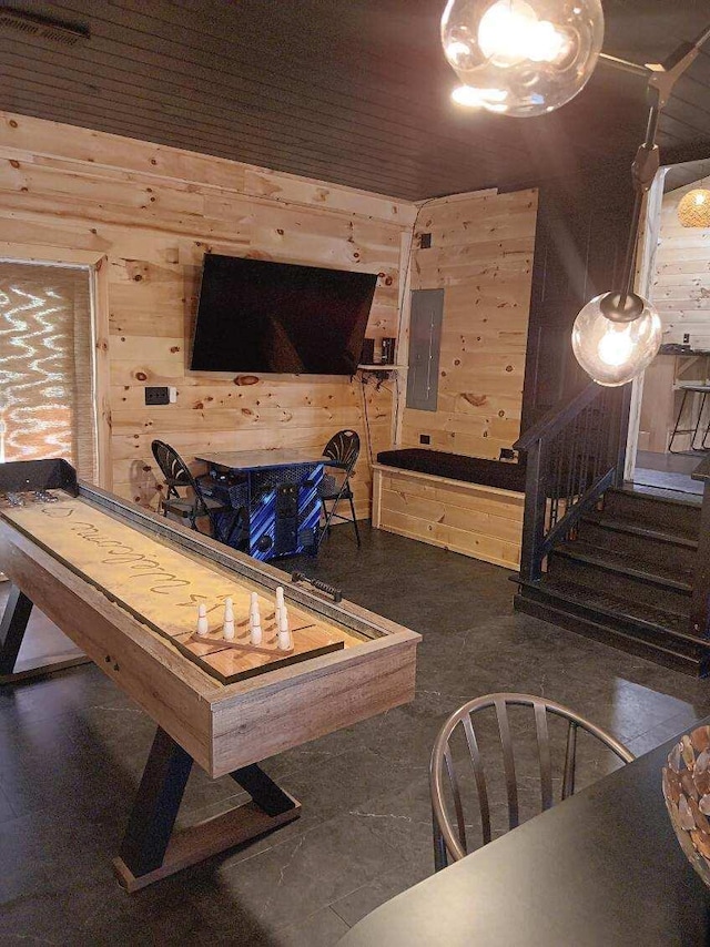 rec room featuring wood walls and electric panel