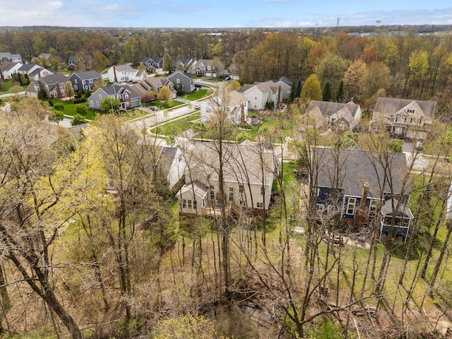 drone / aerial view featuring a residential view and a wooded view
