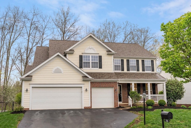 traditional-style house with a porch, a front lawn, aphalt driveway, and roof with shingles