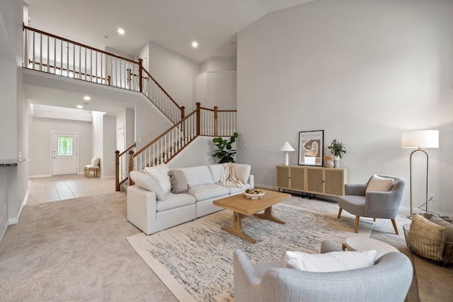 living area with carpet flooring, baseboards, recessed lighting, a high ceiling, and stairs