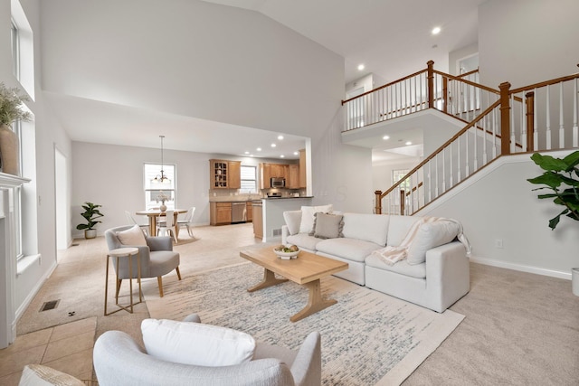 living area with stairway, a high ceiling, recessed lighting, and light carpet
