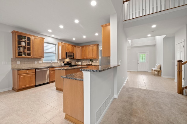 kitchen featuring recessed lighting, appliances with stainless steel finishes, dark stone counters, and light tile patterned floors
