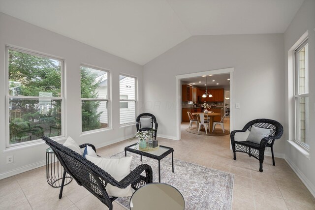 living area featuring vaulted ceiling, a wealth of natural light, and light tile patterned floors