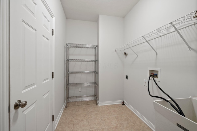 clothes washing area featuring hookup for an electric dryer, baseboards, hookup for a washing machine, laundry area, and light tile patterned floors