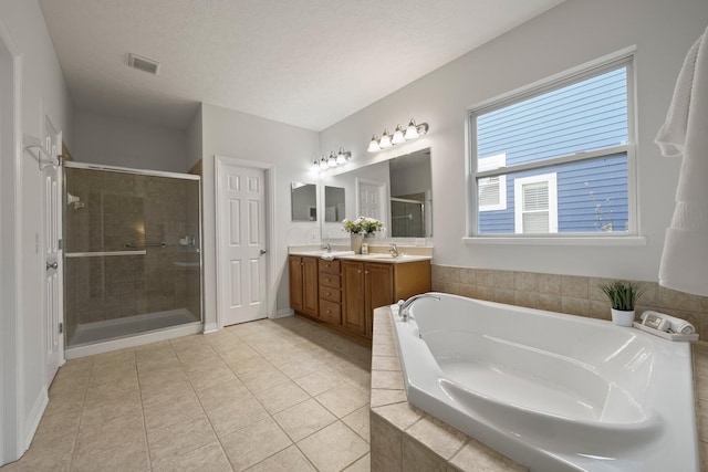 full bath featuring tile patterned floors, double vanity, visible vents, a shower stall, and a garden tub