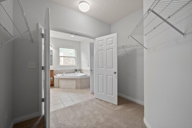 walk in closet with light tile patterned floors and light colored carpet