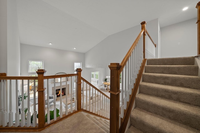 stairway with recessed lighting, lofted ceiling, and a wealth of natural light