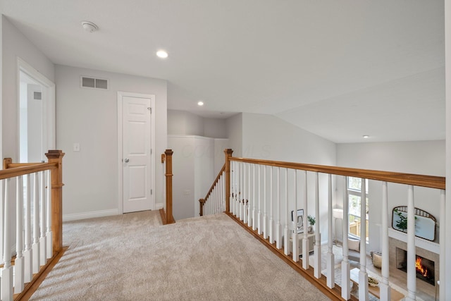 hallway featuring baseboards, recessed lighting, visible vents, carpet, and an upstairs landing