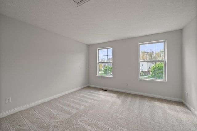 empty room featuring baseboards, carpet floors, and a textured ceiling