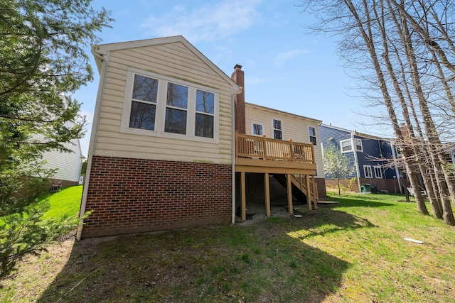 rear view of property featuring a yard, stairs, and a deck