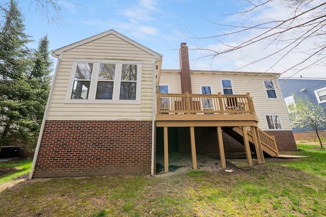 rear view of property with stairway, a wooden deck, a chimney, and brick siding