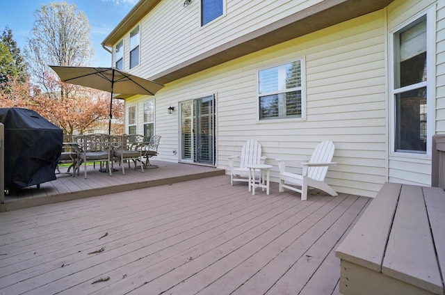 wooden terrace featuring outdoor dining area and grilling area
