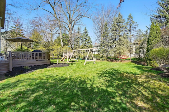 view of yard with a wooden deck and a playground