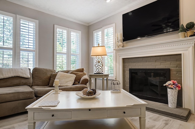 living room with a fireplace, light wood-type flooring, and crown molding