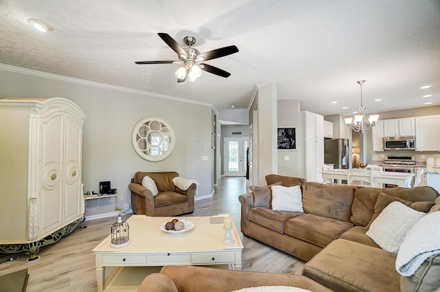 living area with light wood-style flooring, baseboards, ornamental molding, and ceiling fan with notable chandelier