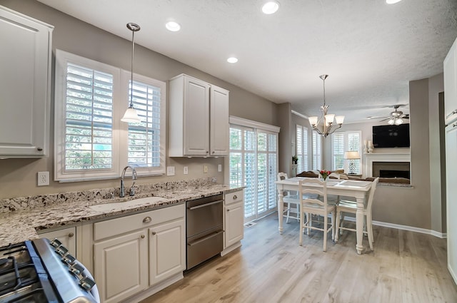 kitchen featuring gas range oven, light wood finished floors, recessed lighting, and a sink