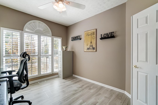 office space featuring ceiling fan, baseboards, visible vents, and light wood finished floors