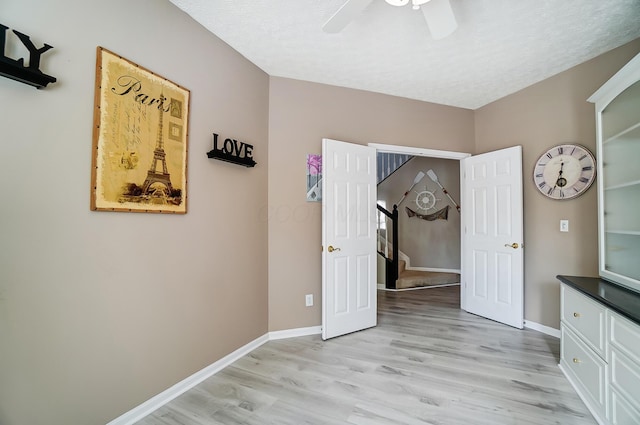 unfurnished bedroom featuring baseboards, a ceiling fan, and light wood-type flooring
