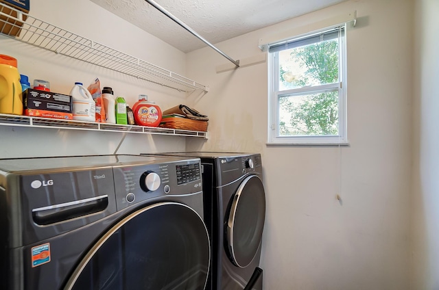 laundry area featuring washing machine and dryer, a textured ceiling, and laundry area