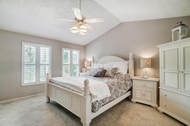 bedroom with vaulted ceiling, baseboards, visible vents, light colored carpet, and a ceiling fan