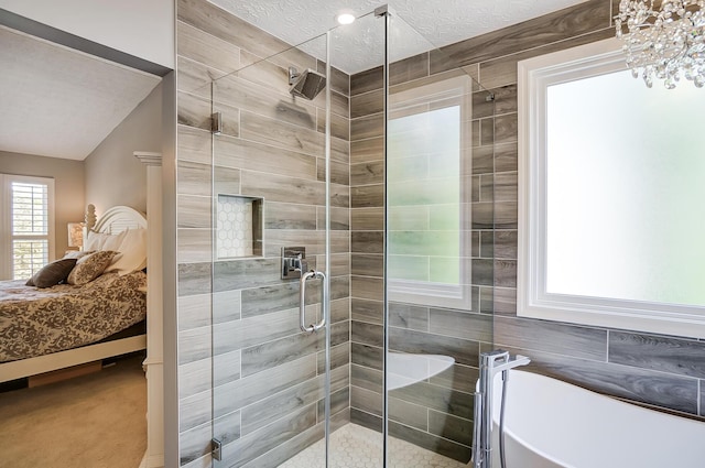 ensuite bathroom with ensuite bath, a textured ceiling, a freestanding bath, and a stall shower