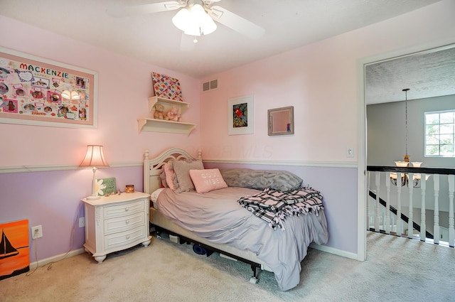 carpeted bedroom featuring baseboards, a ceiling fan, and visible vents
